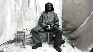 Мужик в плаще и маске дрочит на стуле до оргазма и спускает сперму в пакет